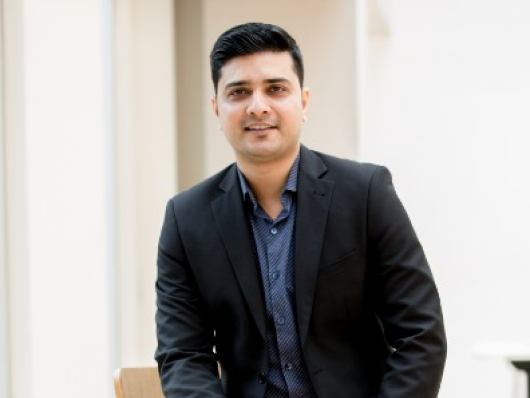 Man in black suit sitting on a chair