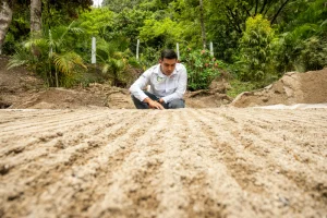 Construction expert inspecting natural earth base layer at a sustainable building site in India.